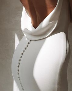 the back of a woman's white dress with buttons