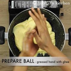 someone is kneading dough in a pan on the stove top with their hands