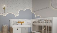 a baby's room with clouds painted on the wall and a crib next to it