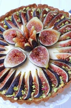 a cake with figs and pistachio on it sitting on a white plate