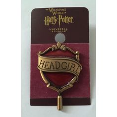 a harry potter badge on top of a red and purple book with the words, headgirl