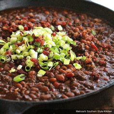 beans and other vegetables are being cooked in a skillet