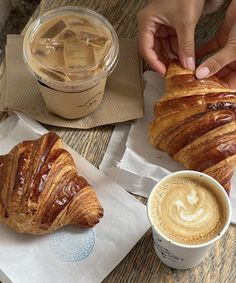 there are two croissants and a cup of coffee on the table next to each other