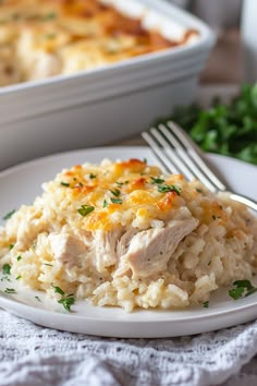 chicken and rice casserole on a white plate with a fork next to it