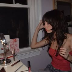 a woman sitting in front of a window with her hand on her head