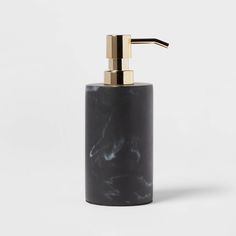 black marble soap dispenser with gold accents on the top and bottom, against a white background