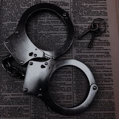 a pair of handcuffs sitting on top of an open book