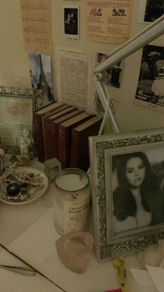 a desk with books, pictures and other items sitting on it's table top