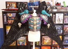 a mannequin dressed in black and purple with wings