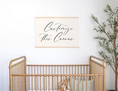 a baby crib in front of a wall with a sign that says cuddle this canvas