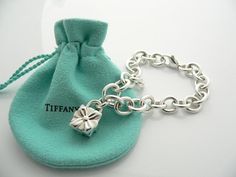 Offered for sale is a wonderful and super cute Tiffany and Co. Sterling Silver Signature Gift Box Charm bracelet.   The piece is made from substantial and bright Tiffany silver, and yet retains a very feminine feel to it.  Attached to its very substantial and bright Tiffany Silver charm bracelet is a super Cool Signature Gift Box Padlock charm.  The Gift Box padlock charm opens and closes, and thus can be used as a charm on a necklace or as part of another charm bracelet! Super versatile piece! Tiffany Charm Bracelet, Pandora Bracelet Charms Ideas, Tiffany And Co Bracelet, Tiffany And Co Jewelry, Pandora Bracelet Charms, Silver Charm Bracelet, Tiffany And Co, Gift Pouch, Ribbon Bow