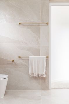 a white toilet sitting next to a wall mounted shower faucet in a bathroom