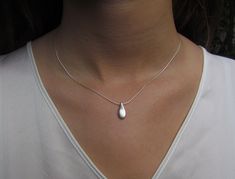 "This hand made teardrop pendant necklace has an effortless, earthy allure. The matte sterling silver pendant hangs at the base of a delicate sterling silver chain. This is the perfect necklace to pair with any casual outfit adding a bohemian vibe. Wear this alone, or layer it with your other favorites for a personalized eclectic look. ❉ F A C T S total length : 16\"/ 42 cm teardrop length: 1\"/ 2.54 cm teardrop width: 0.45\"/ 1.1 cm You will receive the necklace in a gift box ready to be given Minimalist Teardrop Pearl Drop Necklace, Pearl Drop Teardrop Pendant As Gift, Minimalist Pearl Drop Teardrop Necklace, Delicate Silver Teardrop Pendant Necklace, Delicate Sterling Silver Drop Necklace, Delicate Sterling Silver Teardrop Pendant Necklace, Sterling Silver Untreated Teardrop Pendant, Nickel-free Teardrop Metal Necklace, Spiritual Nickel-free Teardrop Necklace