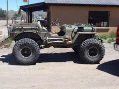 an old army jeep parked in front of a building