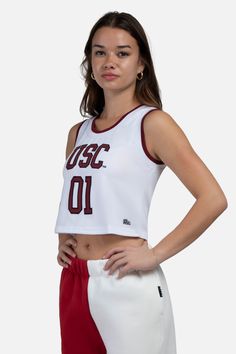 She shoots, she scores! Be the all-star you are in our new Cropped Basketball Jersey! Pair with low rise denim or a mini skirt for a look fit for gameday or everyday. This style features two-color trim and an embroidered twill logo. Have the cutest fit on and off the court! Fit recommendations: True to size, designed to be cropped. Sizing: XS-XXL Embroidered school logo 100% polyester White Sporty Top For Cheerleading, Varsity White Tops For Cheerleading, White Varsity Tops For Cheerleading, White College Style Sports Top, White Stretch School Spirit Top, White Stretch Tops For Game Day, White Stretch Tops For School Spirit, Sporty Tops With Contrast Trim For Sports, Varsity Style White Top With Contrast Color