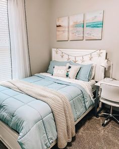 a bed sitting in a bedroom next to a window with white curtains and blue comforter