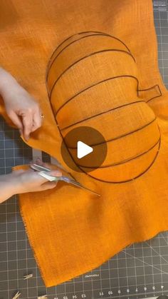 someone using scissors to cut out a piece of fabric