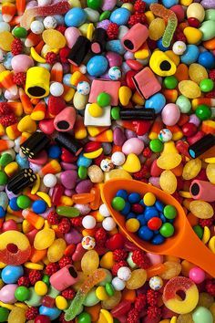 a pile of colorful candy and candies with a pair of scissors in the middle