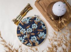 a blue and gold embroidered wall hanging next to a wooden box with a white mouse on it