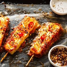 grilled chicken skewers with marinara sauce and seasoning on a baking sheet