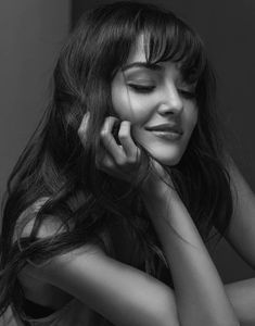 a black and white photo of a woman talking on a cell phone with her eyes closed