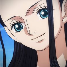 a close up of a person with blue eyes and long black hair looking at the camera