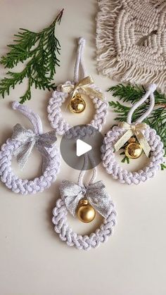 crochet christmas ornaments with bells and pine cones hanging from the strings on a white table