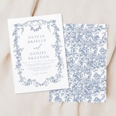 a wedding card with a blue floral design on it and a white envelope that says, ollivia briele & daniel preston