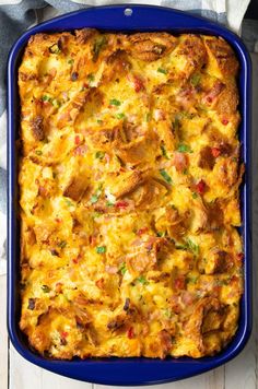 a casserole with meat and cheese in a blue dish on a white wooden table