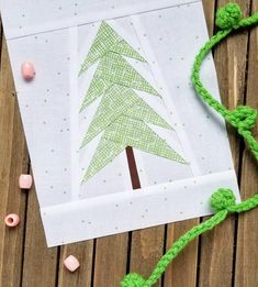 a piece of paper with a green christmas tree on it next to some crochet beads