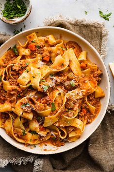 a white bowl filled with pasta and meat sauce