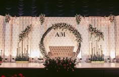 the stage is decorated with flowers and greenery