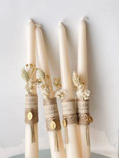 three candles are wrapped in twine and decorated with flowers