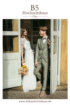 a bride and groom standing in front of an open door