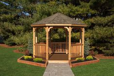 a wooden gazebo sitting on top of a lush green field