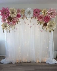 a white curtain with pink flowers and lights on the bottom is in front of a window