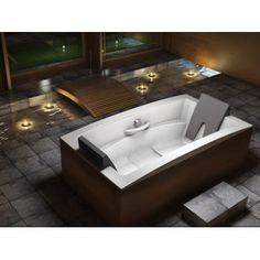 a large bath tub sitting on top of a tiled floor next to a wooden bench