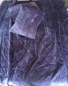 an unmade bed with purple sheets on it