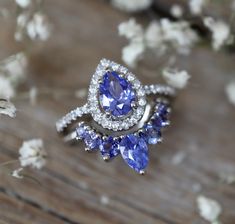 two blue and white rings sitting on top of a wooden table next to some flowers