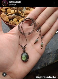 a hand holding a long necklace with beads