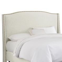 an upholstered headboard with white linens and beading on the sides