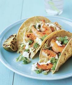 three shrimp tacos on a blue plate