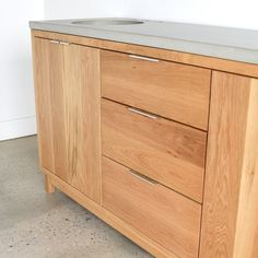 a close up of a wooden cabinet with a white counter top and grey marble top