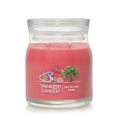 yankee candle in glass jar with pink wax and white lid, on a white background