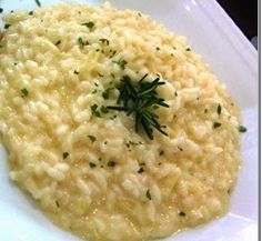 a white plate topped with macaroni and cheese covered in parmesan sauce