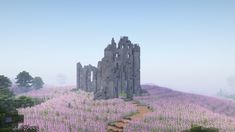 a very tall castle sitting on top of a lush green hillside covered in purple flowers