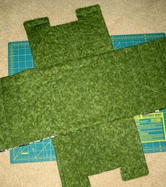 three pieces of fabric are laid out on the floor to make a quilted turtle