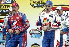 three men in racing uniforms standing on a stage