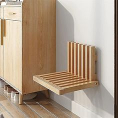 a wooden cabinet sitting on top of a hard wood floor next to a white wall