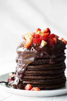 a stack of chocolate pancakes with strawberries on top